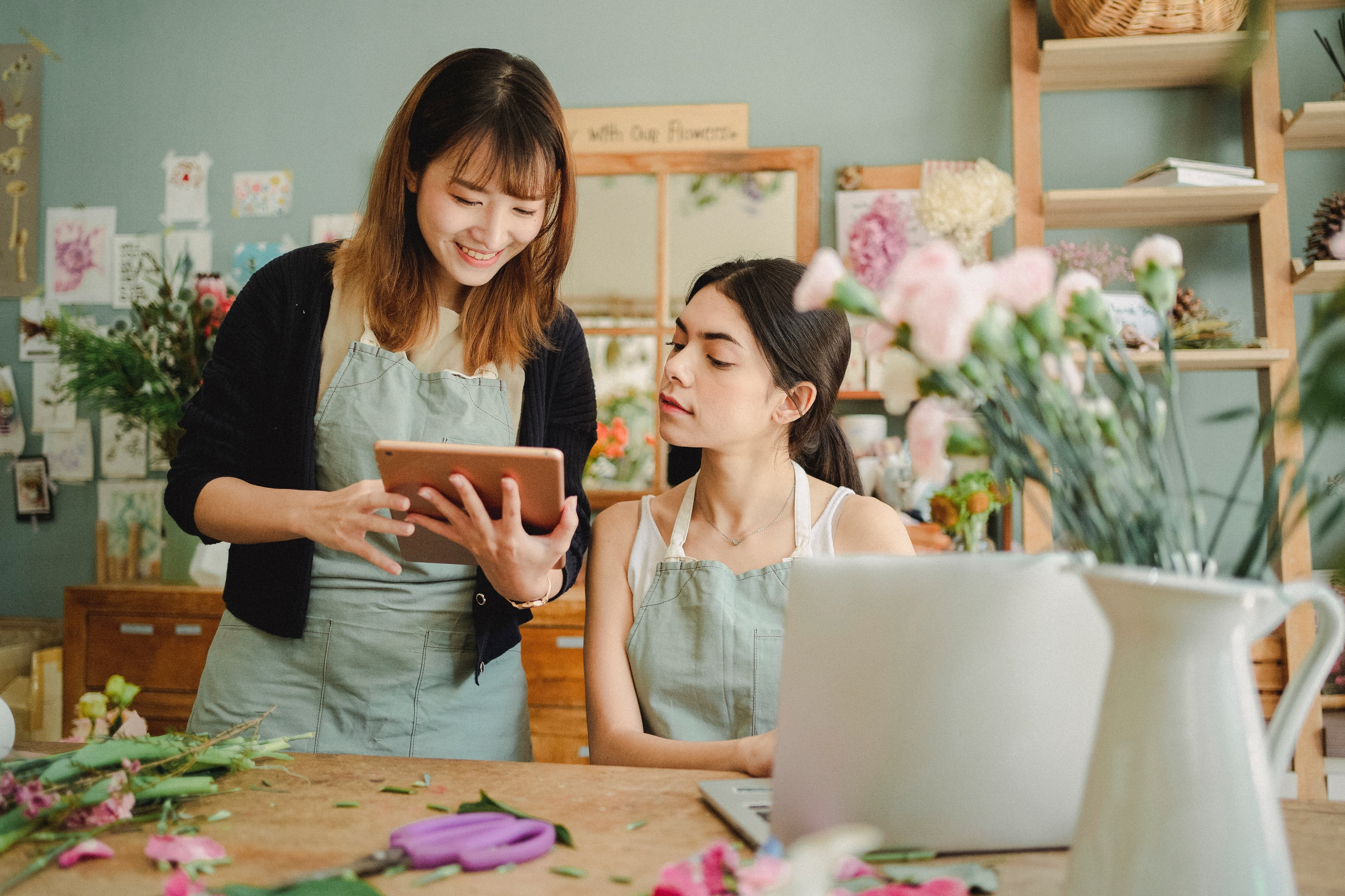 Image of a business owner looking at QuickBooks sales in the flower shop with a team member.